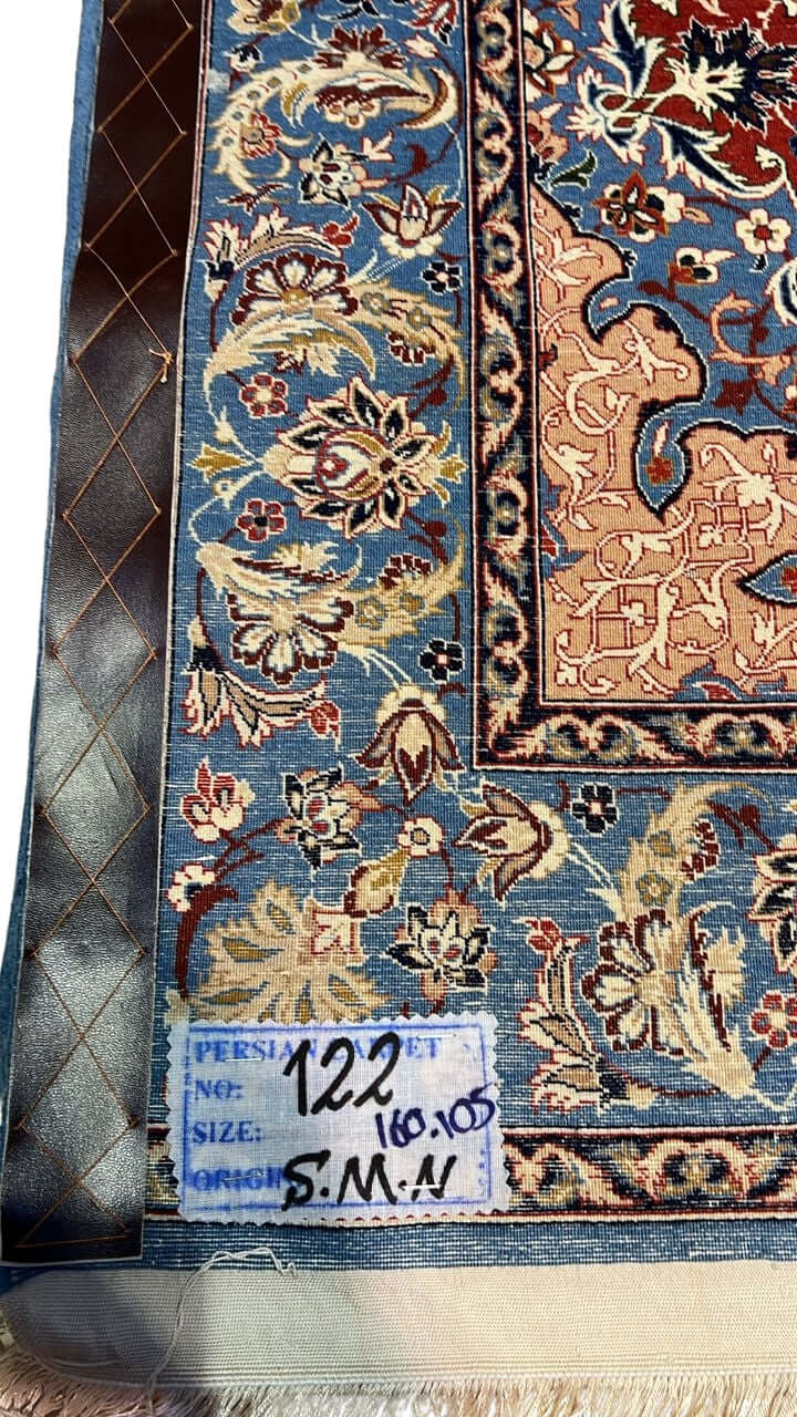 "Backside of a handwoven Seirafian silk carpet, displaying fine knot craftsmanship with silk warp and wool pile, highlighting intricate floral patterns from Isfahan."